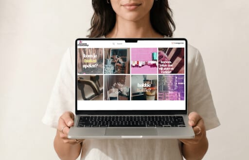 A person holding a laptop showing the Simone Francooijs portfolio