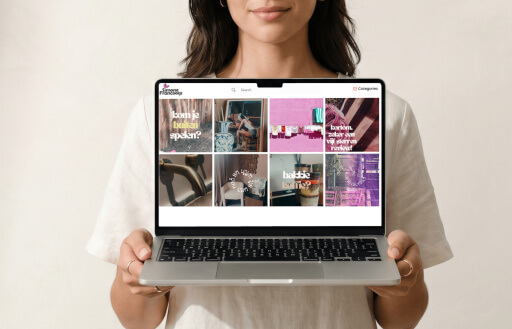 A person holding a laptop showing the Simone Francooijs portfolio